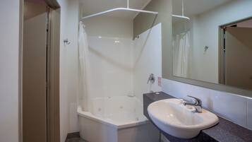 Une salle de bain avec une baignoire, un lavabo et un miroir.