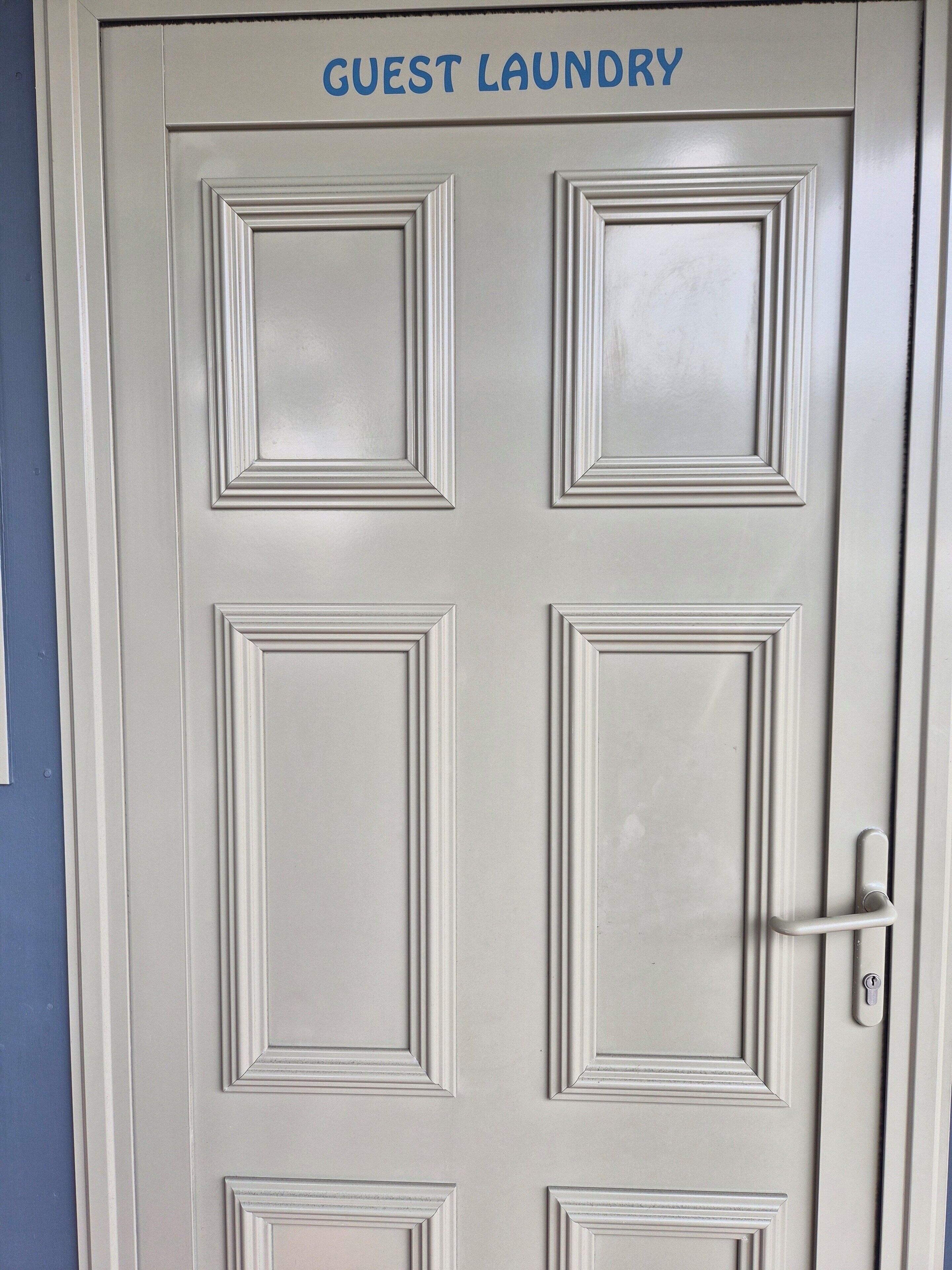 A door with the sign "GUEST LAUNDRY" indicating a facility for guests to use.
