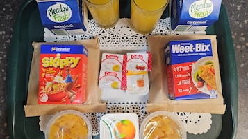 A tray with Meadow Fresh milk cartons, Skippy cereal, Weet-Bix, and two fruit containers.