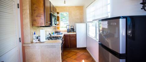 Una cocina compacta equipada con estufa, microondas y refrigerador.