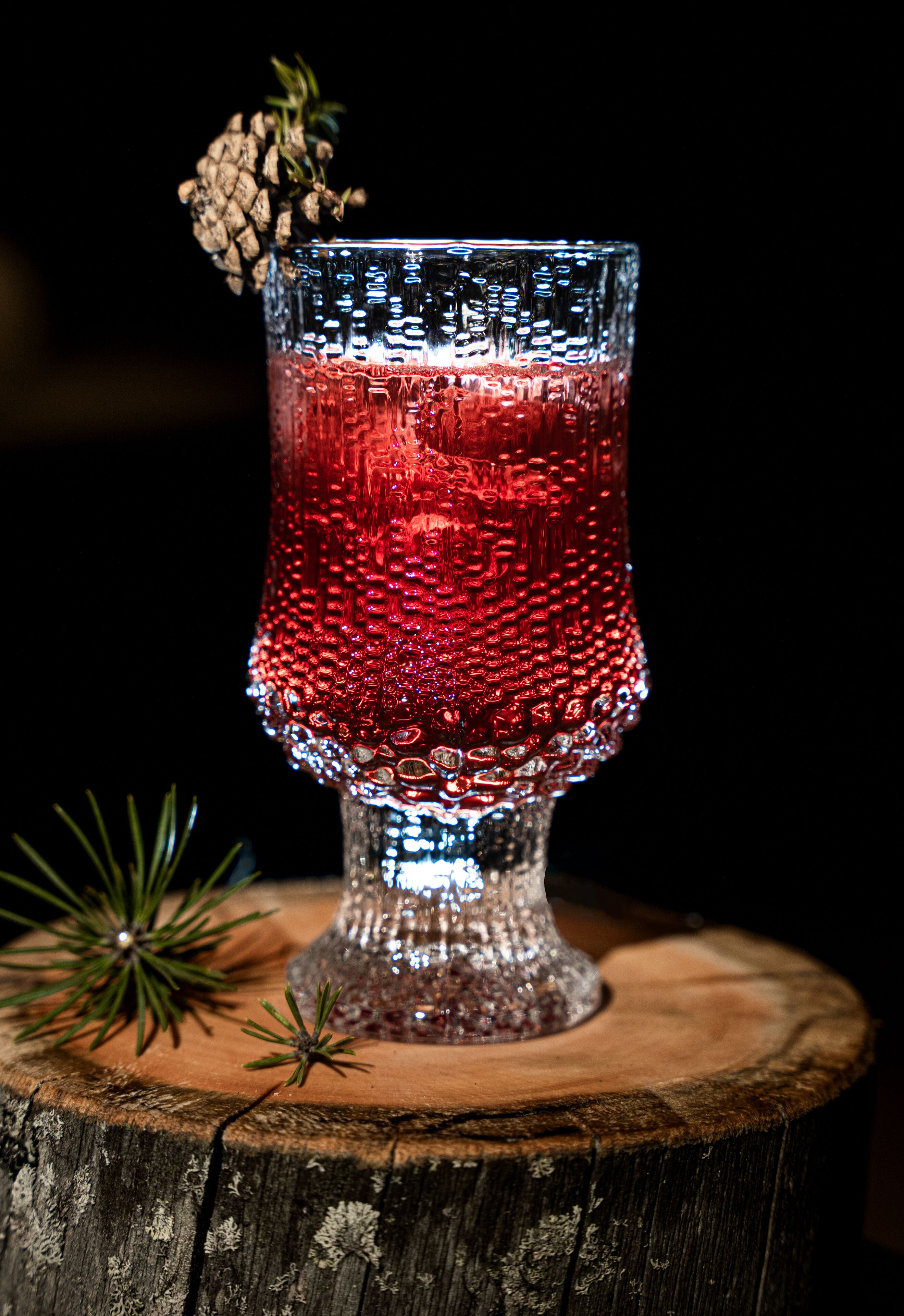 A clear glass with a textured pattern, placed on a wooden surface.