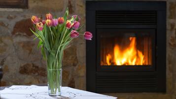 Een vaas met tulpen op een tafel voor een open haard.