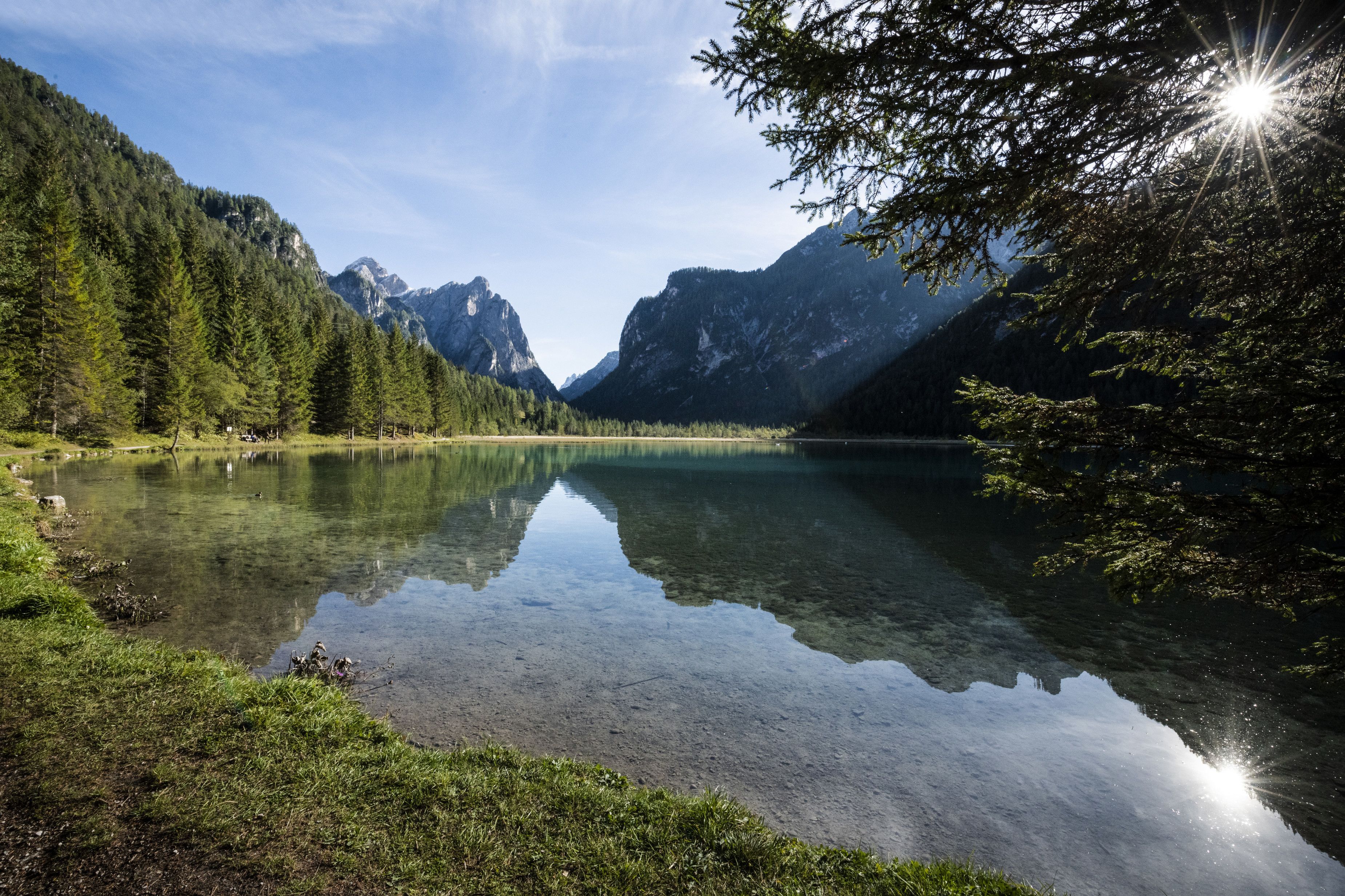 Un lac paisible, entouré d’une forêt dense et de montagnes.