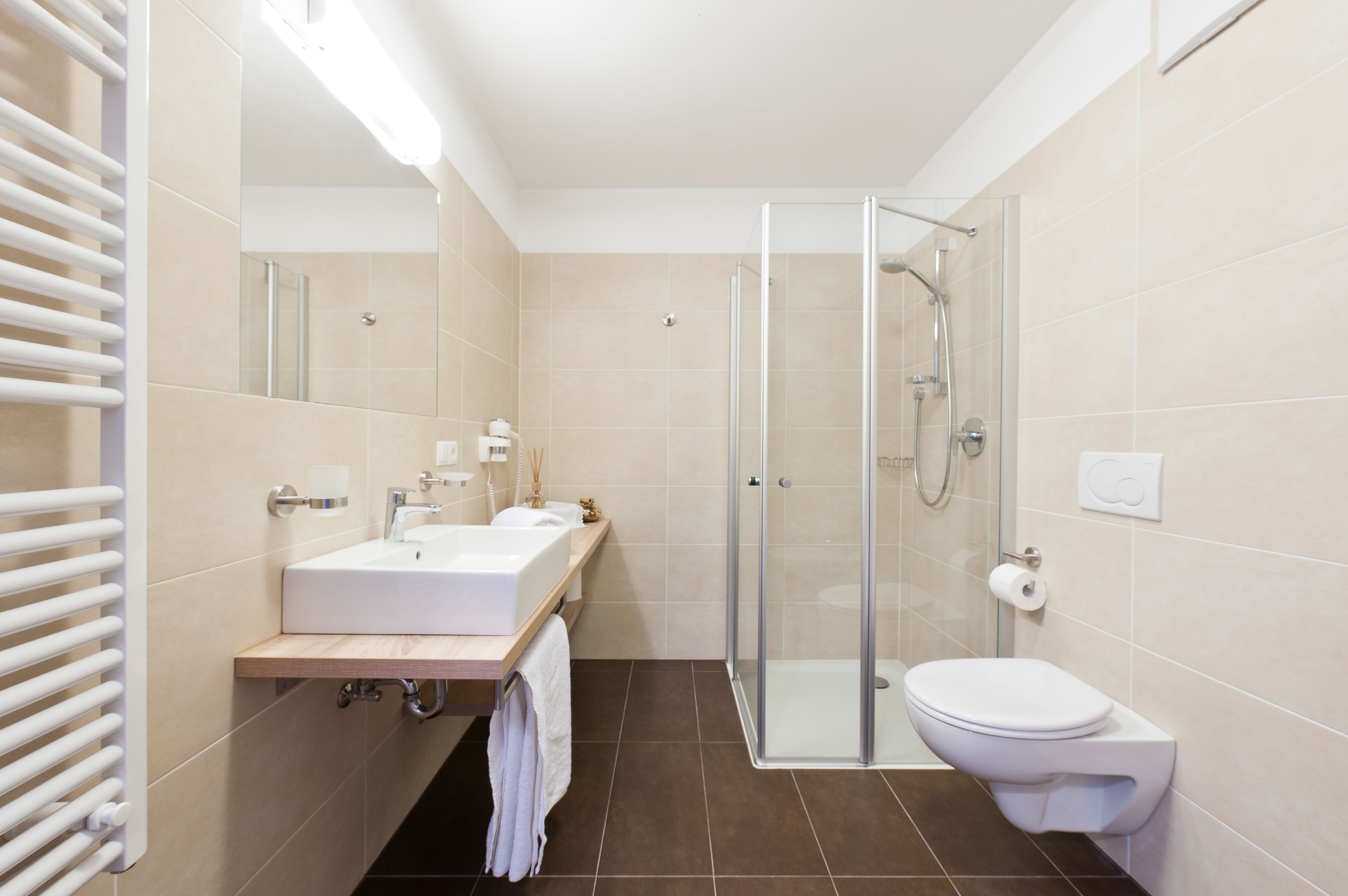 A modern bathroom with a glass-enclosed shower, a sink with a mirror, and a toilet.