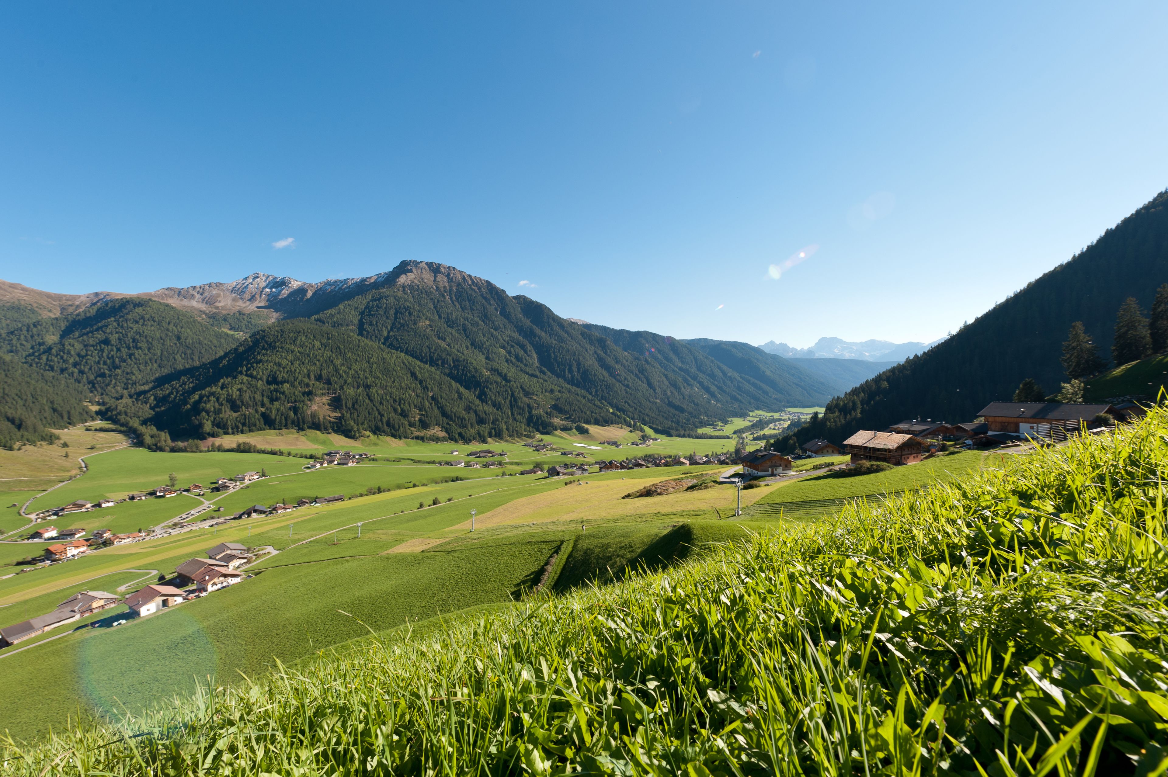 Un paysage rural avec des maisons, un lac et des montagnes.
