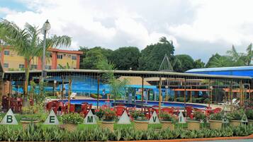 Um resort com área de estar ao ar livre, piscina e um edifício com um mural.