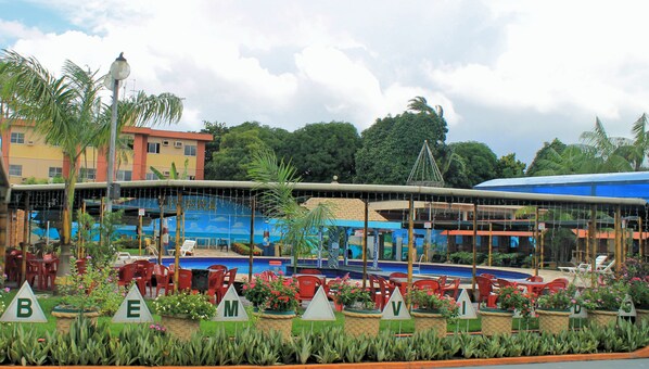 Un resort con mobiliario exterior, piscina y un edificio con un mural.