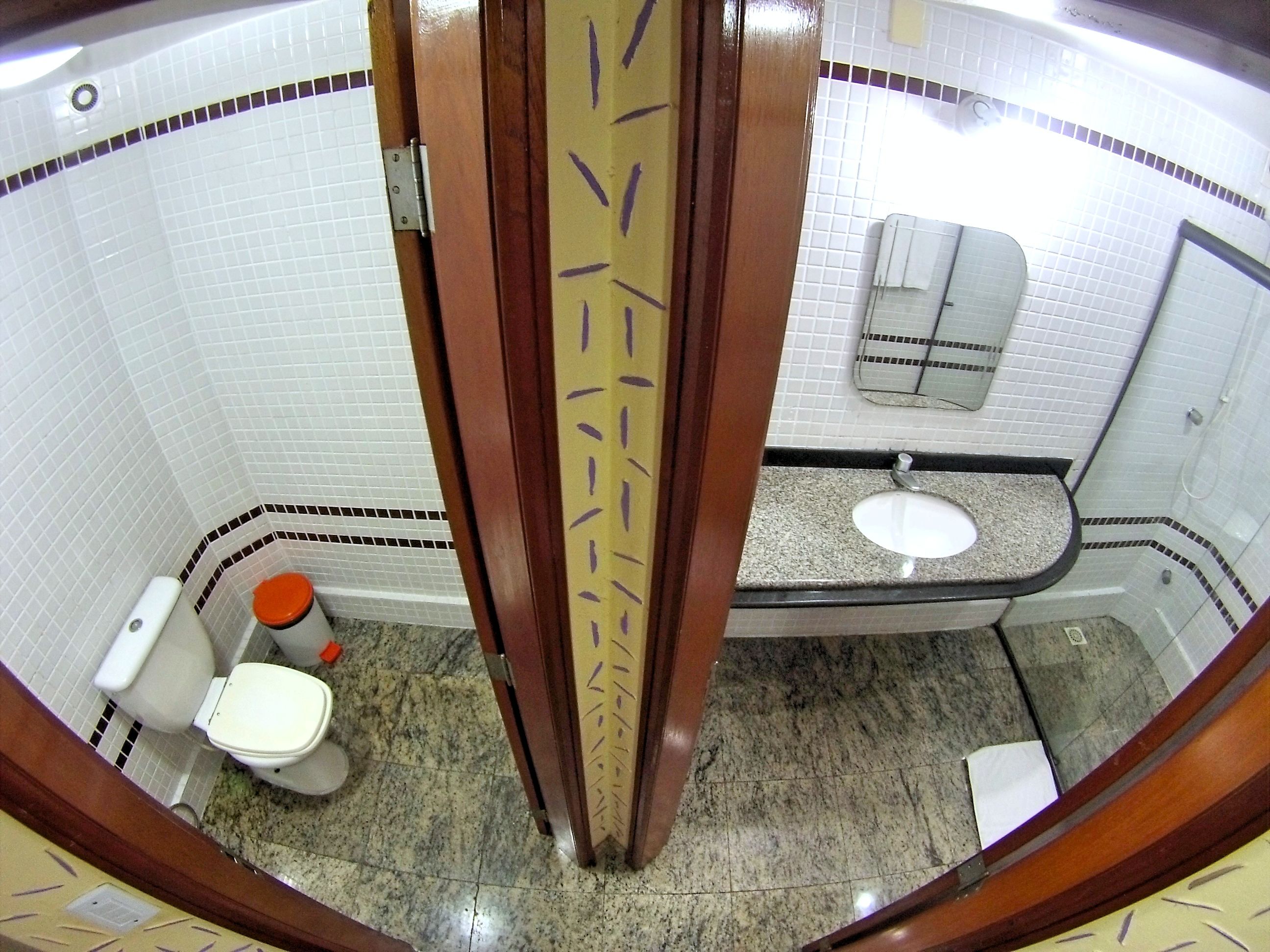 Un baño con inodoro blanco, lavabo y ducha.