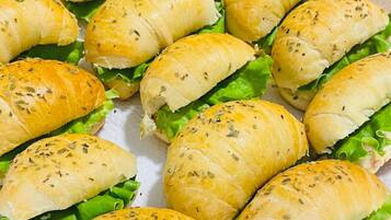 A tray of sandwiches with bread rolls and lettuce.