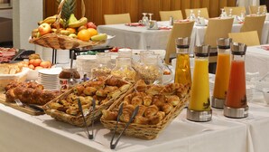 A breakfast buffet with various food items, including fruits, pastries, and beverages.