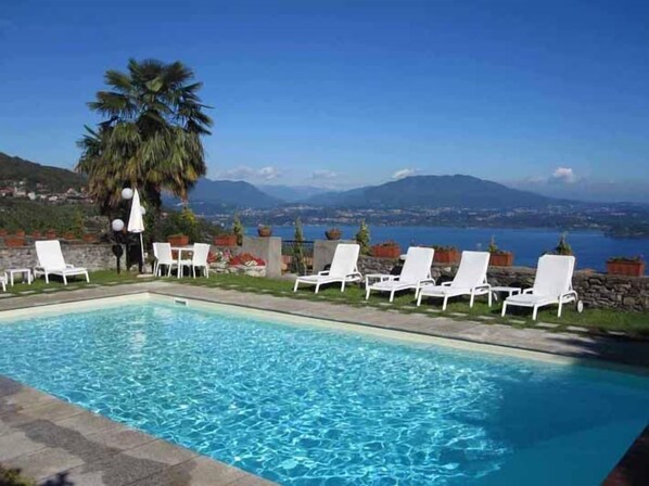 Alberca al aire libre, sombrillas en la alberca y camastros 