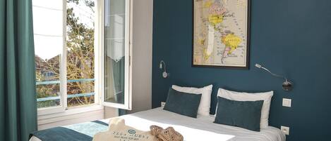 Un dormitorio con cama, un mapa en la pared y una ventana con cortinas.