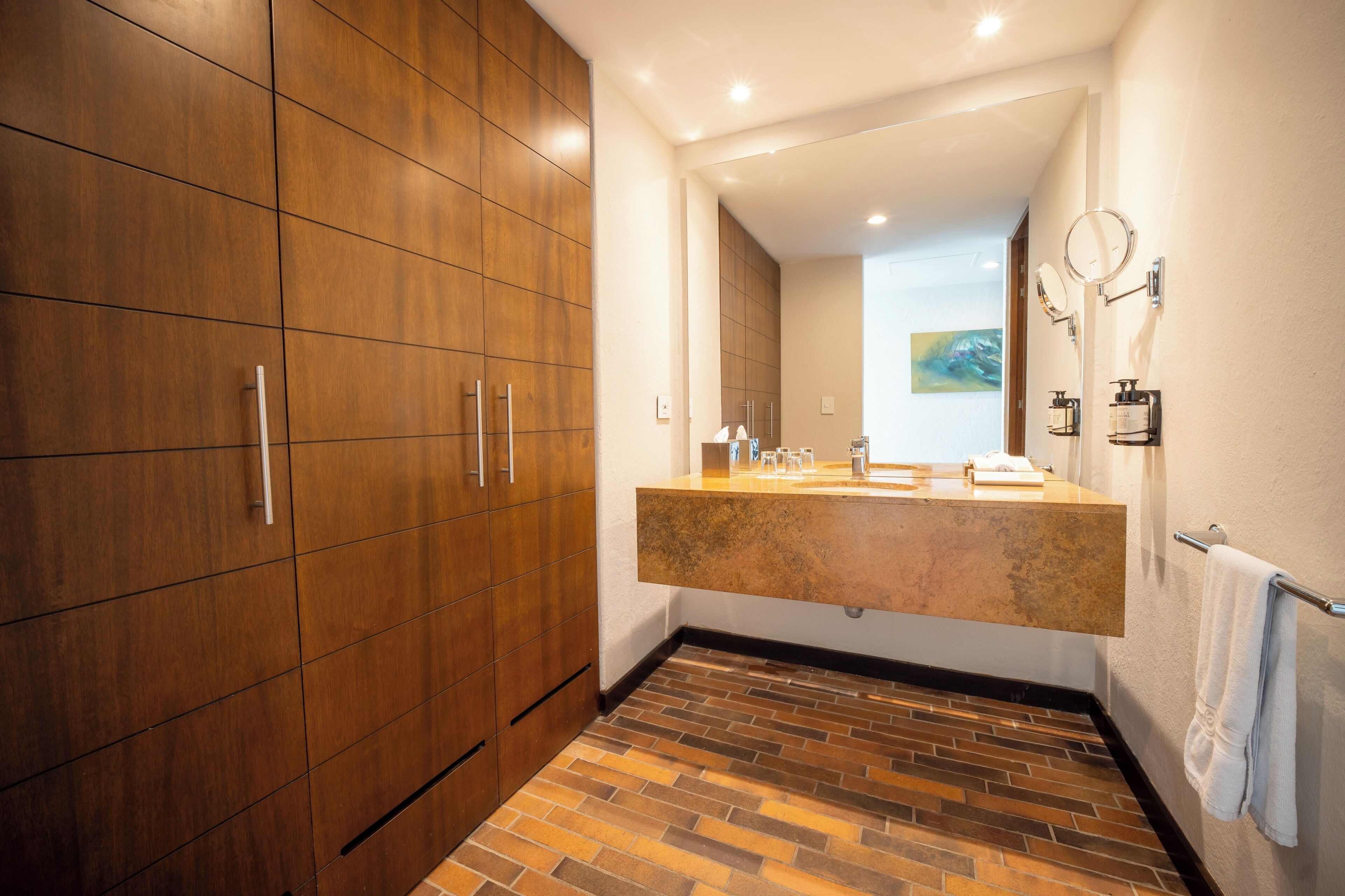 Une salle de bain moderne avec un meuble-lavabo en bois, un grand miroir et un sol carrelé.