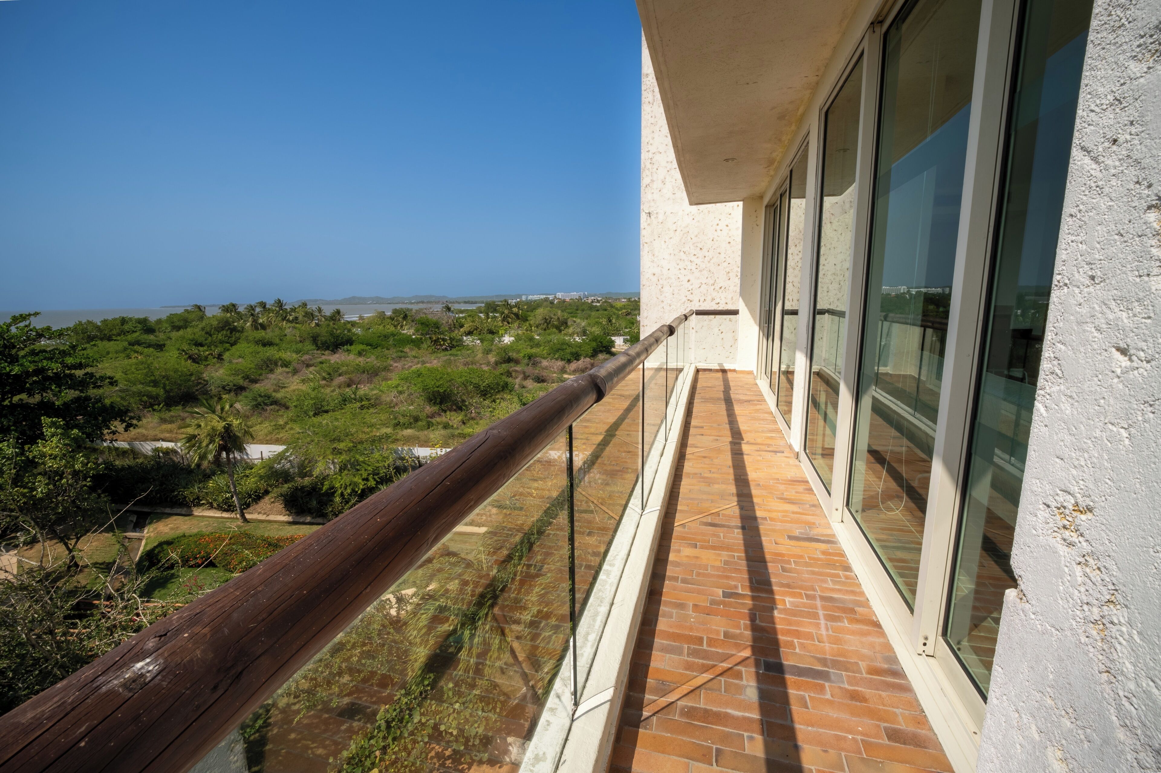Un balcon avec vue sur la mer et la verdure.