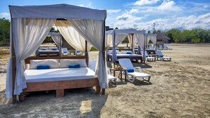 A beach resort with canopy beds and lounge chairs. - Hotel Estelar Playa Manzanillo (Cartagena)