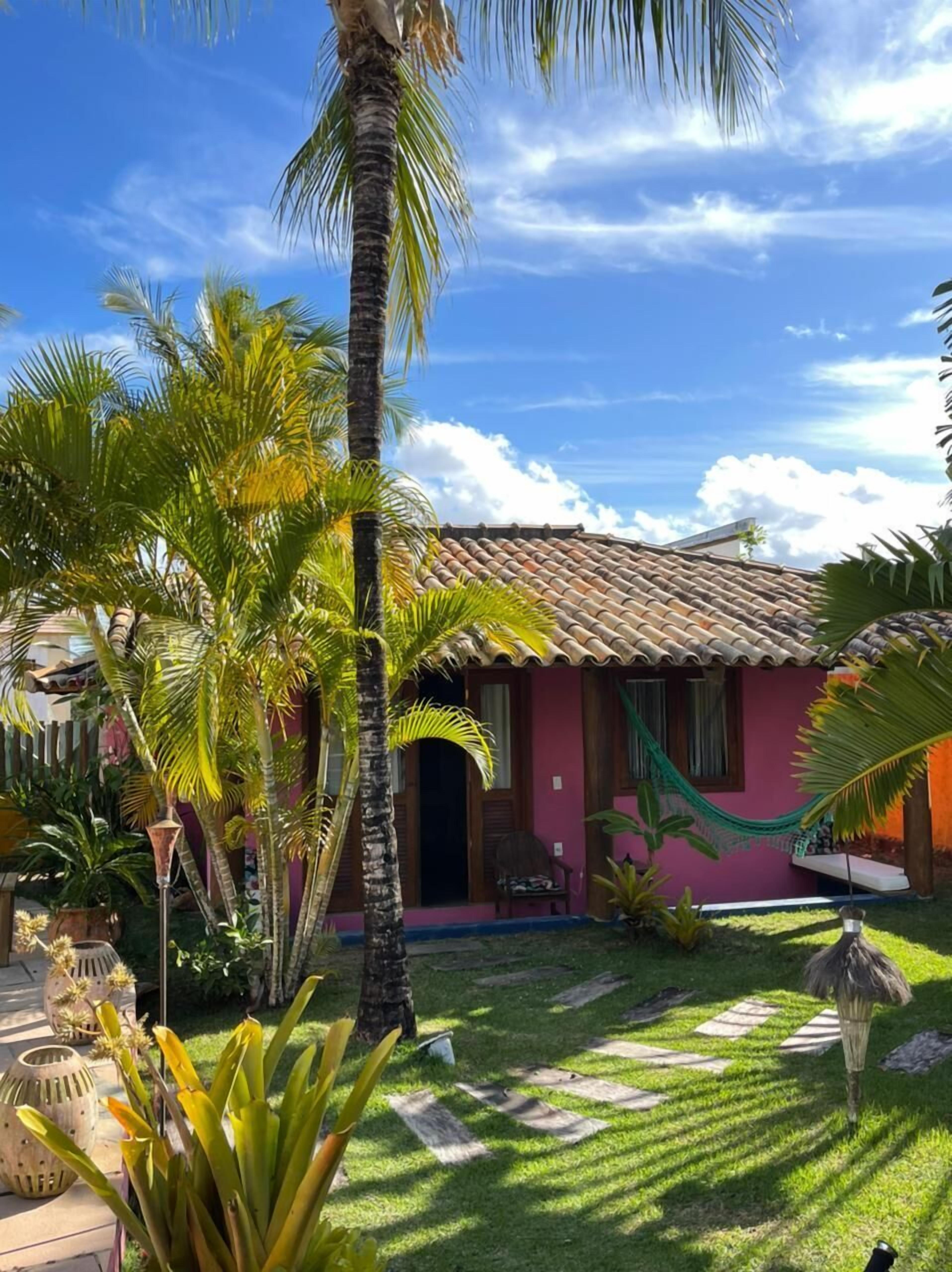 A cozy, single-story house with a tiled roof and a pink exterior.