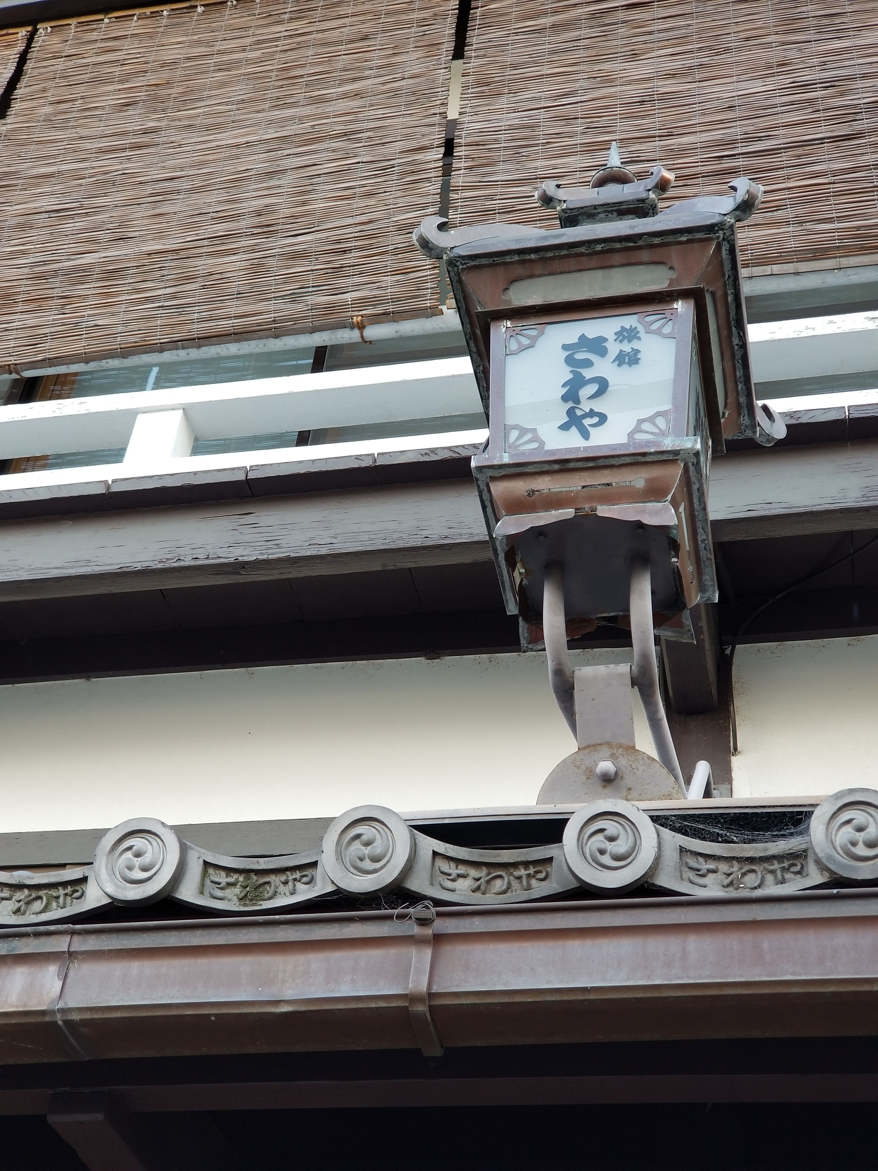Un edificio tradicional japonés con tejado de tejas y un farol decorativo.