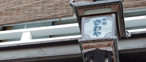 Un edificio tradicional japonés con tejado de tejas y un farol decorativo.