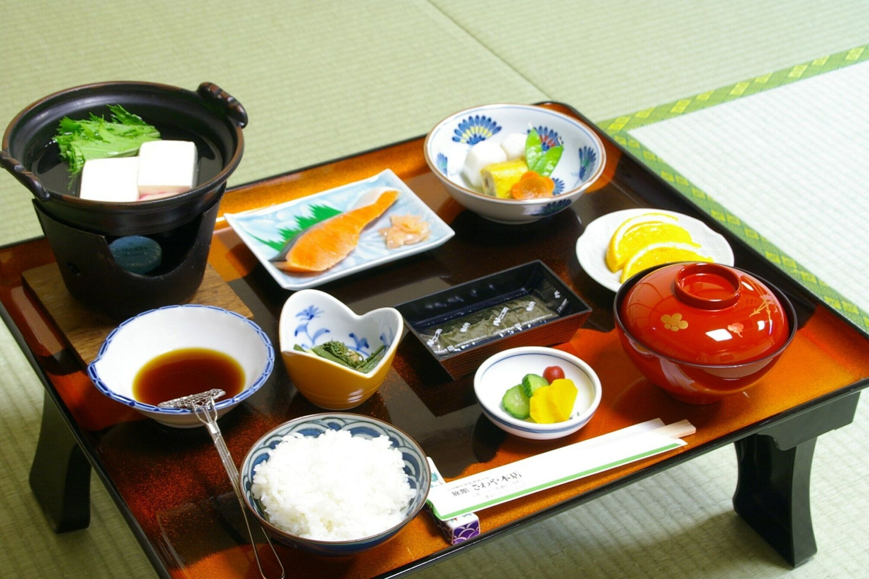 A traditional Japanese meal setup with various dishes and utensils on a tray.