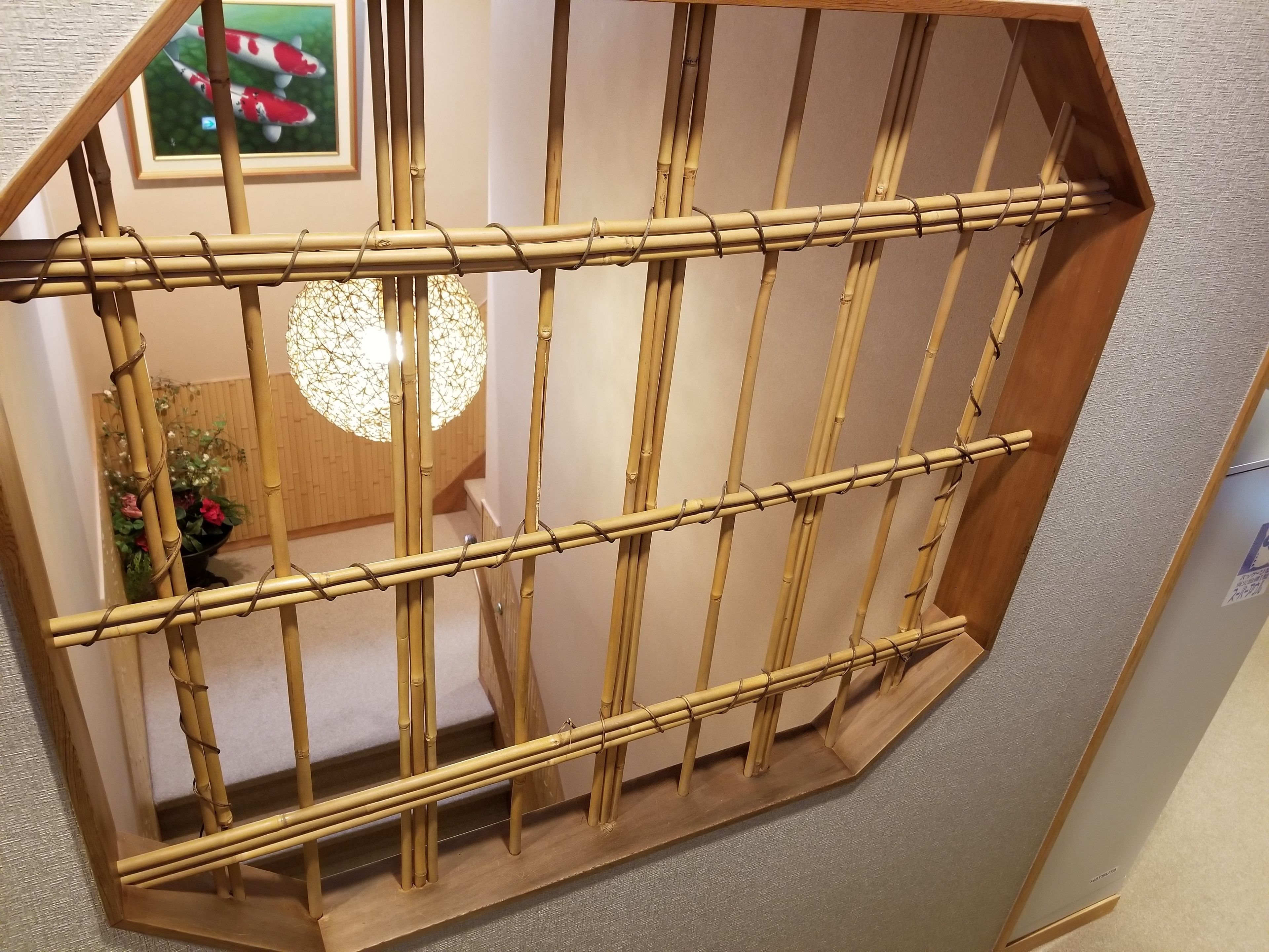 A bamboo-framed window with a view of a room interior.
