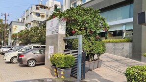 Edificio Royal Orchid Central con un letrero que indica que es un hotel. Hay coches aparcados y una entrada porticada con plantas en macetas.