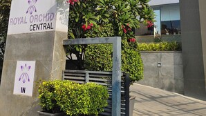 Un edificio de varios pisos con un letrero que dice "Royal Orchid Central" y un logotipo.