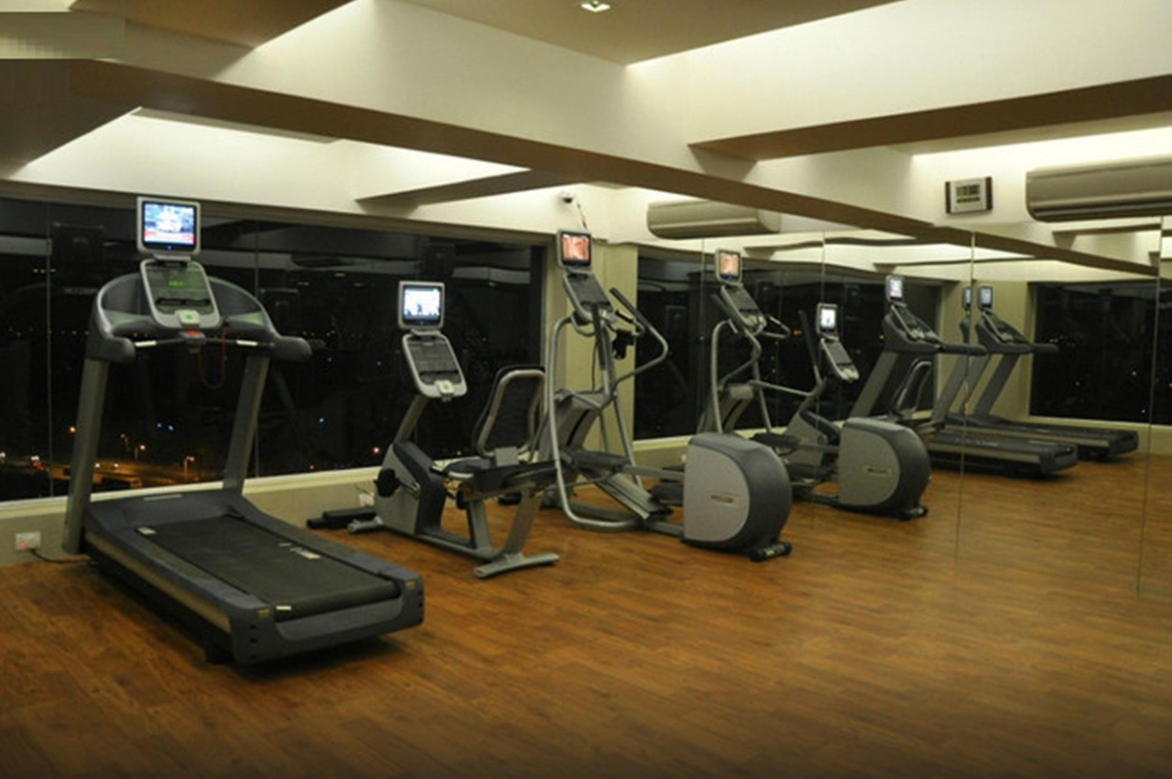 A gym with treadmills, elliptical machines, and a stationary bike.
