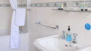 A bathroom with a shower, a sink, a mirror, and a towel rack. - The Blacksmiths Arms (Lewes)