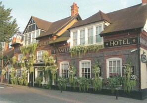 A traditional brick building with multiple windows and hanging flower baskets.