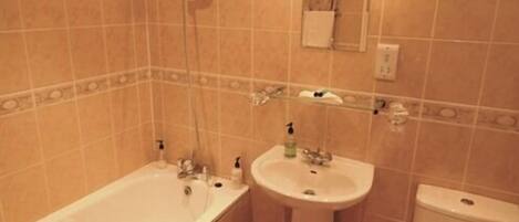 A bathroom with a bathtub, sink, and toilet.