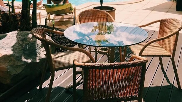 A poolside area with lounge chairs, a table, and a small garden. - La Chaumette Porte des Suds (Privas)
