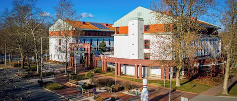Un hotel con diseño moderno, que destaca por su entrada principal, un espacio al aire libre cubierto y un estacionamiento.