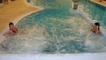 An indoor swimming pool with two people in the water.