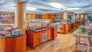 A buffet area with multiple food stations, a coffee bar, and a seating area with tables and chairs.