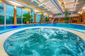 Una piscina techada, sillones reclinables de piscina