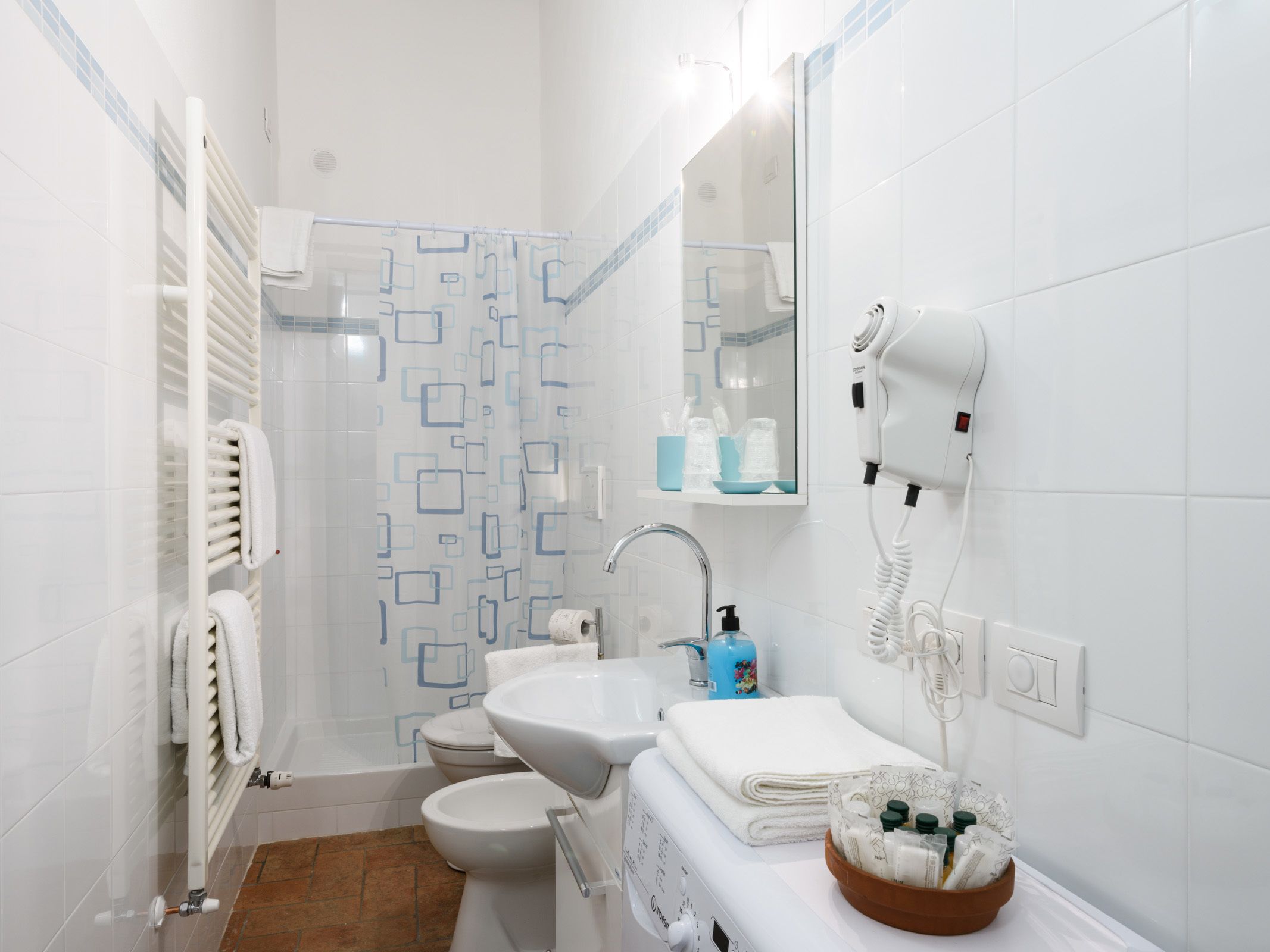 Un baño con inodoro, lavamanos y zona de ducha.