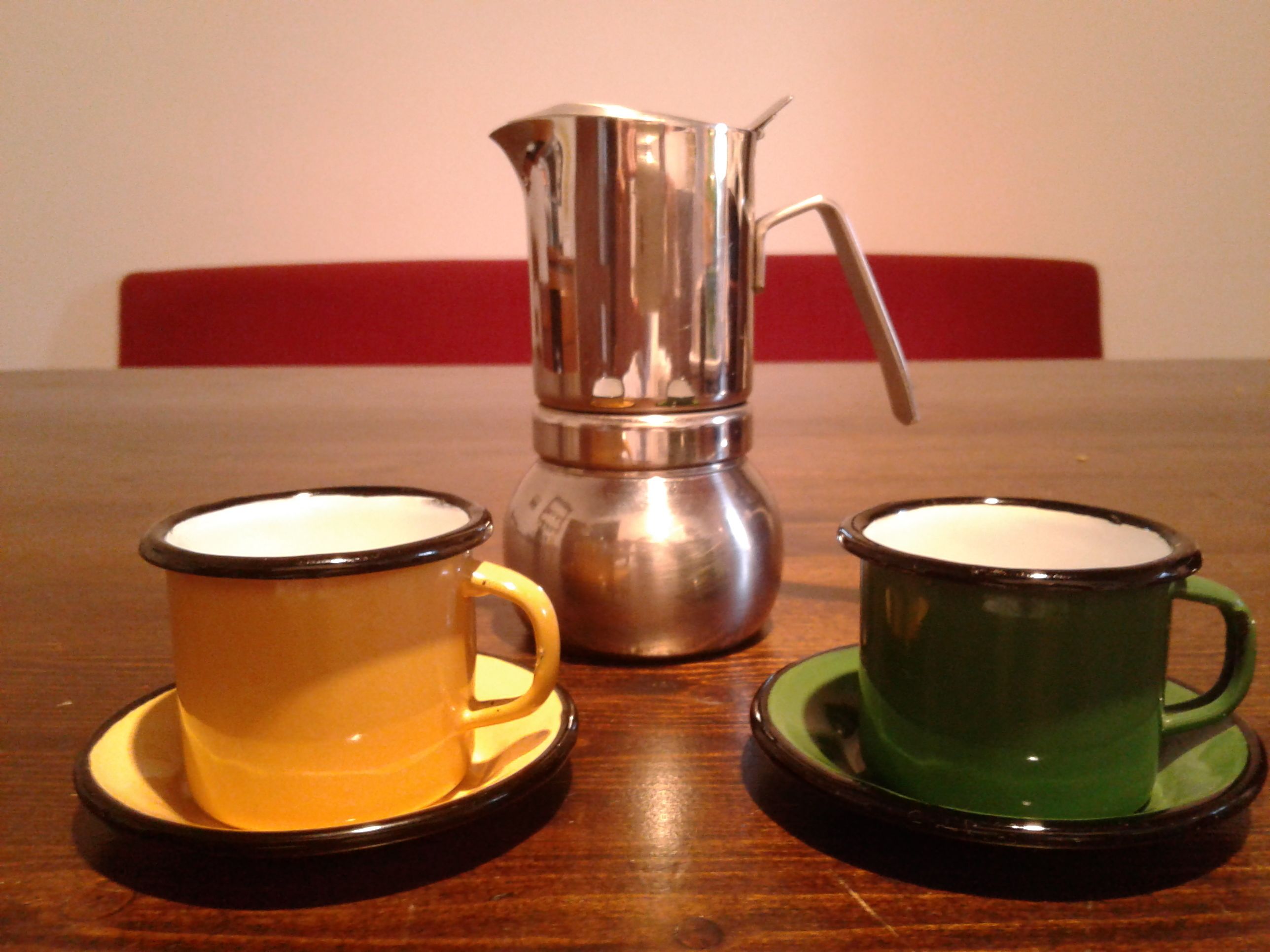 Une table avec deux tasses et une cafetière.