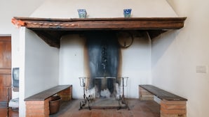 A fireplace with a brick surround and a tiled floor. - Agriturismo Barbi (Pienza)