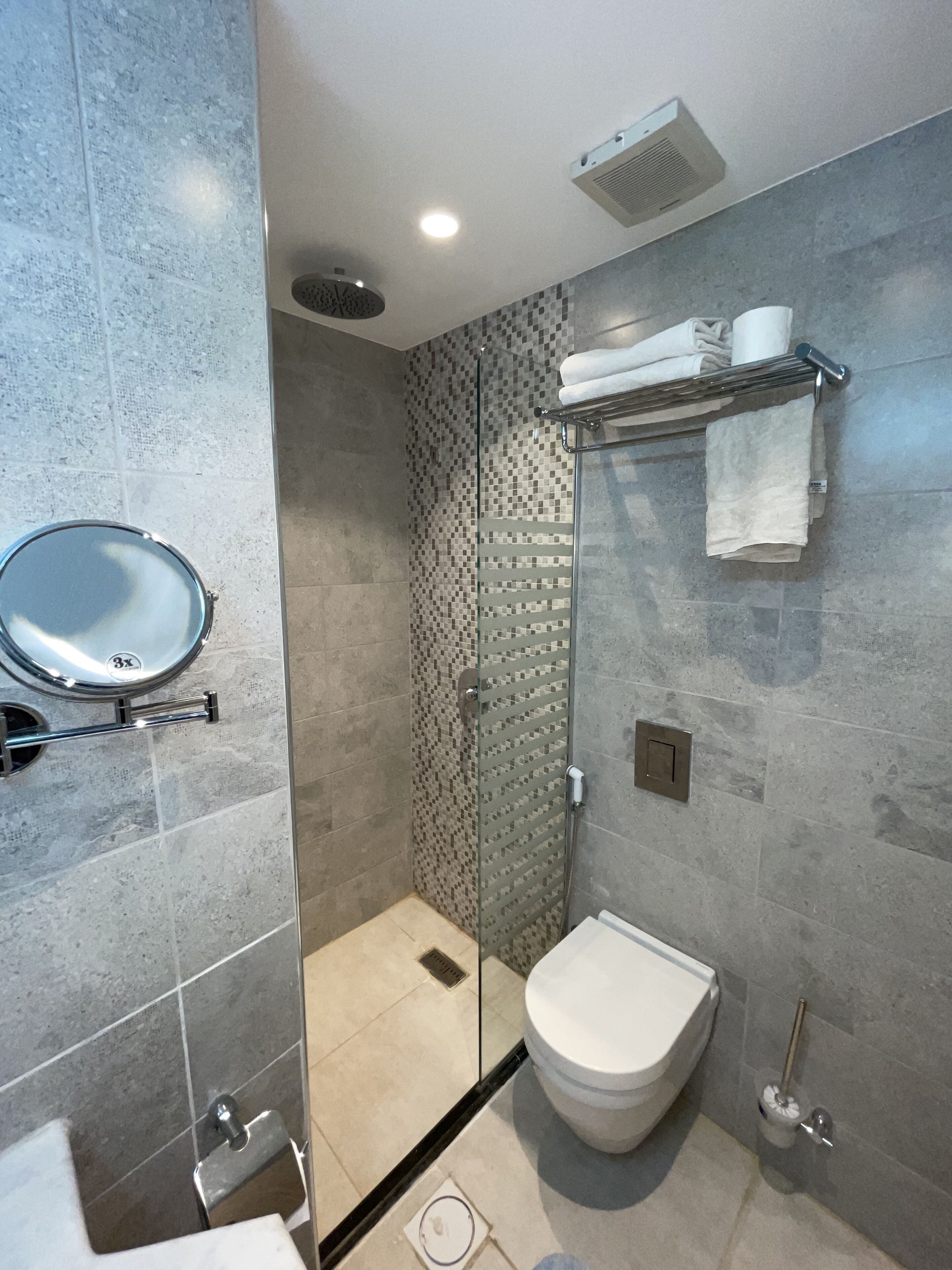 Ein modernes Badezimmer mit Duschkabine, Toilette, Waschbecken und Handtuchhalter.