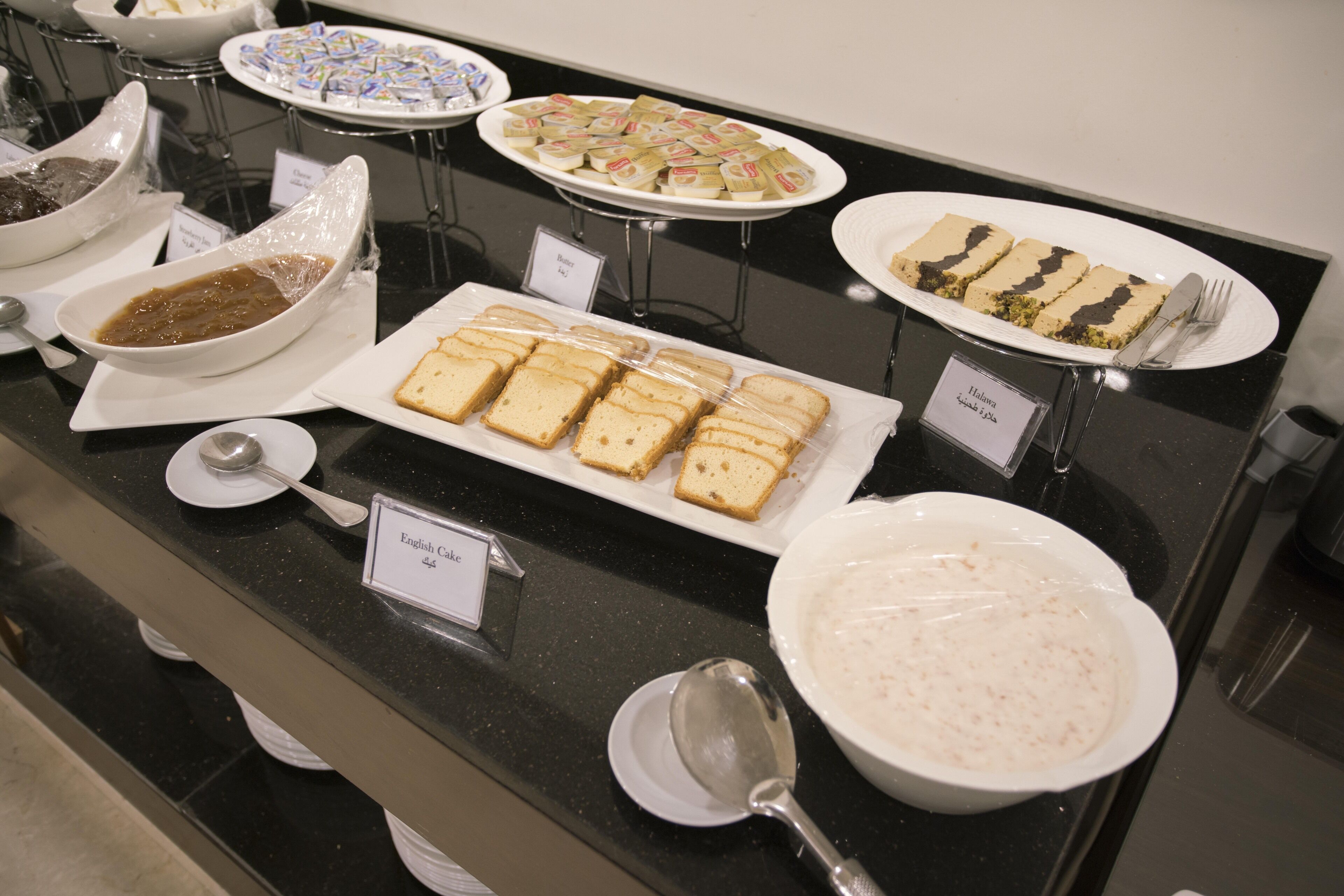 A buffet with various dishes including bread, salad, and desserts.