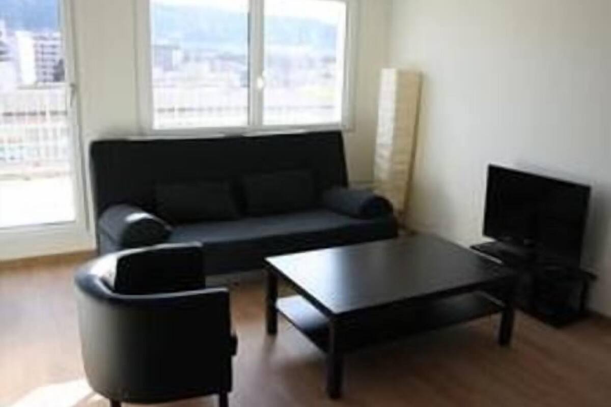 A living room with a sofa, a coffee table, and a TV.