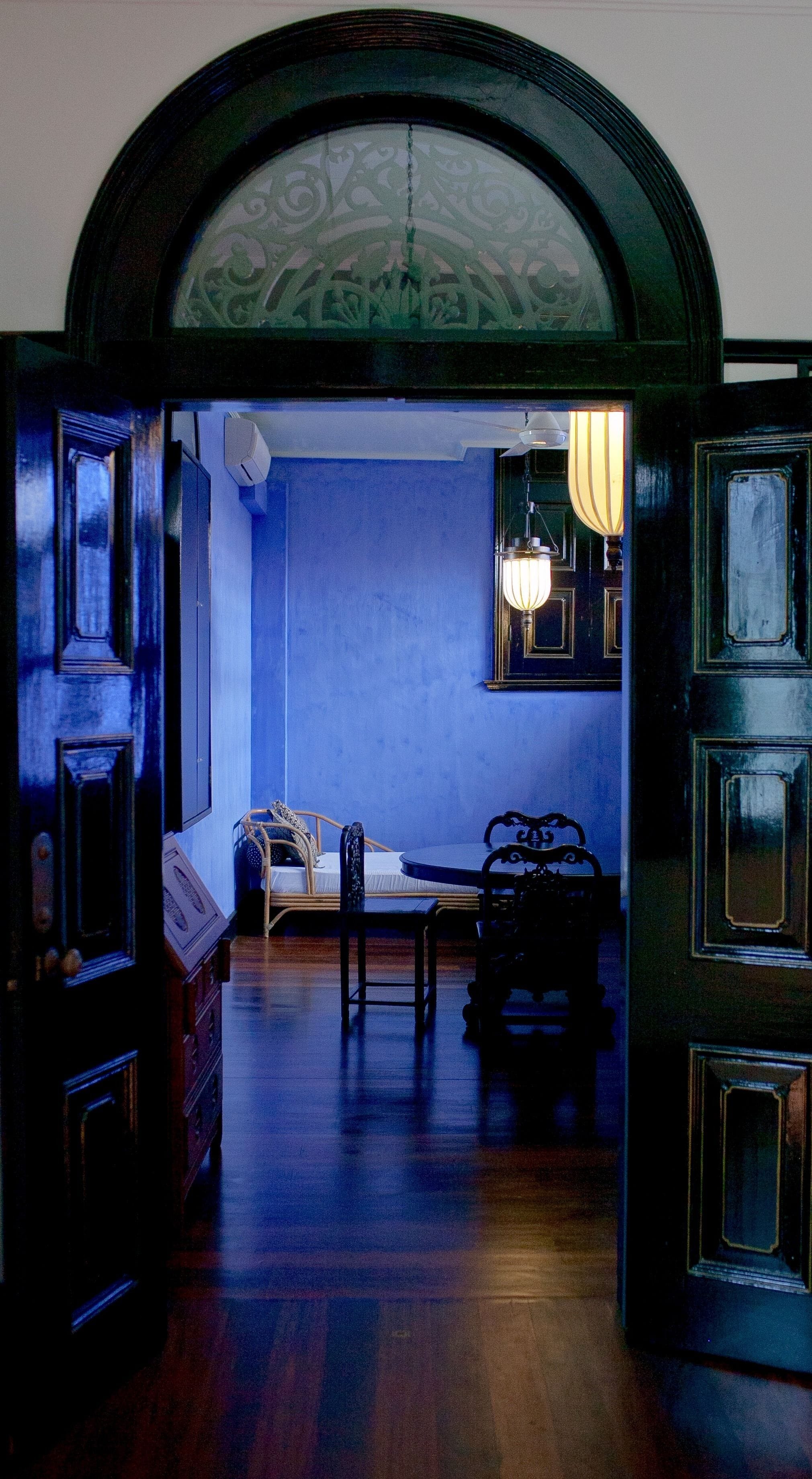 A room with a blue wall, a bed, a desk, and a chair.