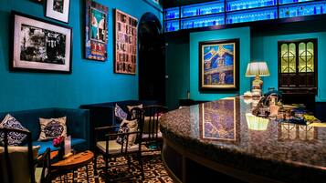 A bar area with a blue wall, framed pictures, and a patterned floor.