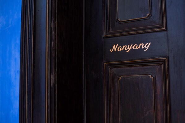 A dark wooden door with the name "Nanyang" in gold lettering. - Cheong Fatt Tze - The Blue Mansion (George Town)
