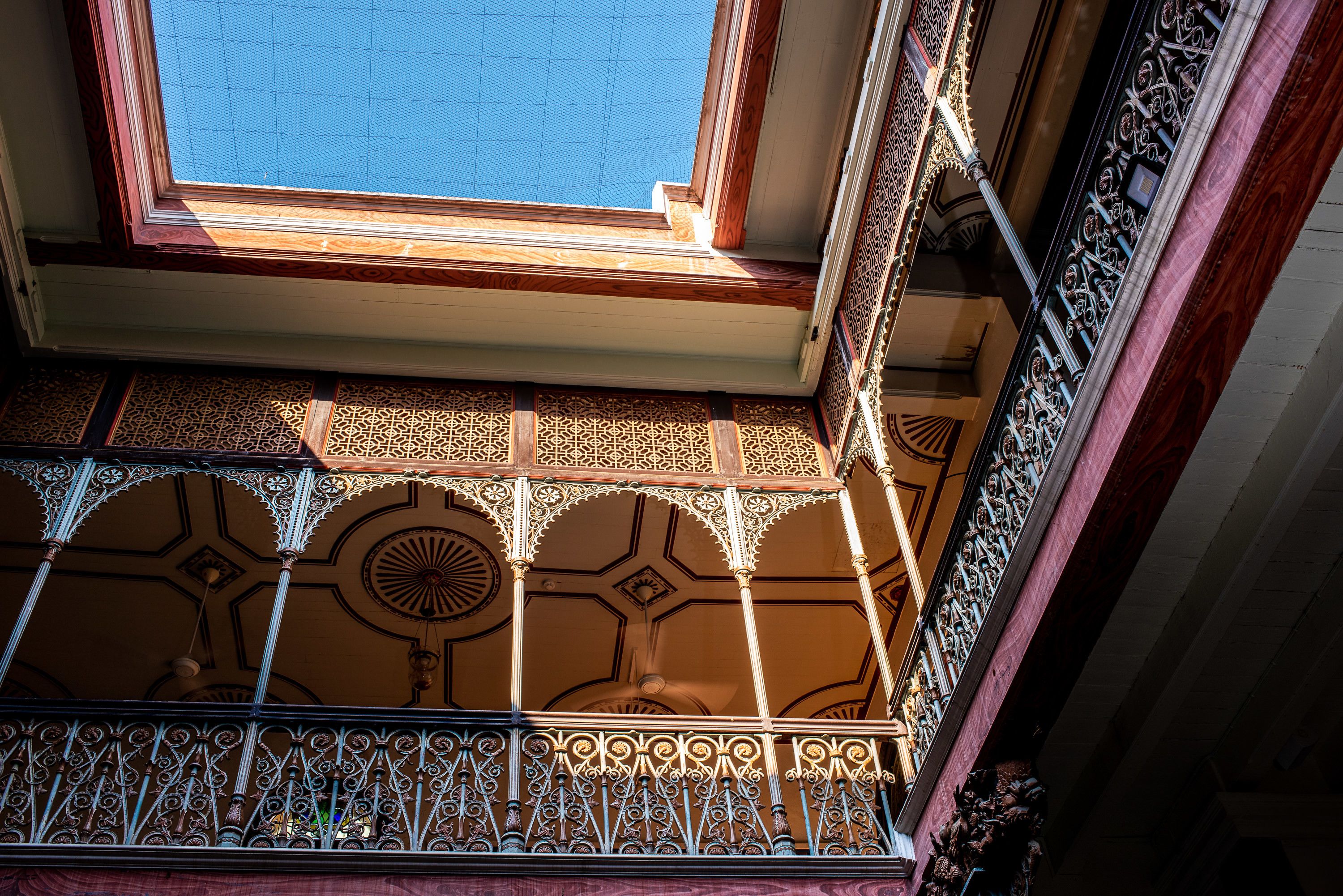 A balcony with ornate metal railings and a patterned tile floor.