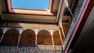 A balcony with ornate metal railings and a patterned tile floor.