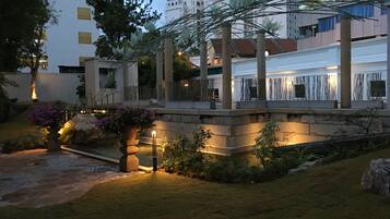 Una piscina al aire libre, sombrillas, sillones reclinables de piscina