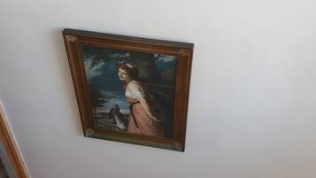 A framed painting on a plain wall.
