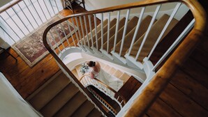 A wooden staircase with a white railing and carpeted steps. - St Vincent Guest House (Lynton)