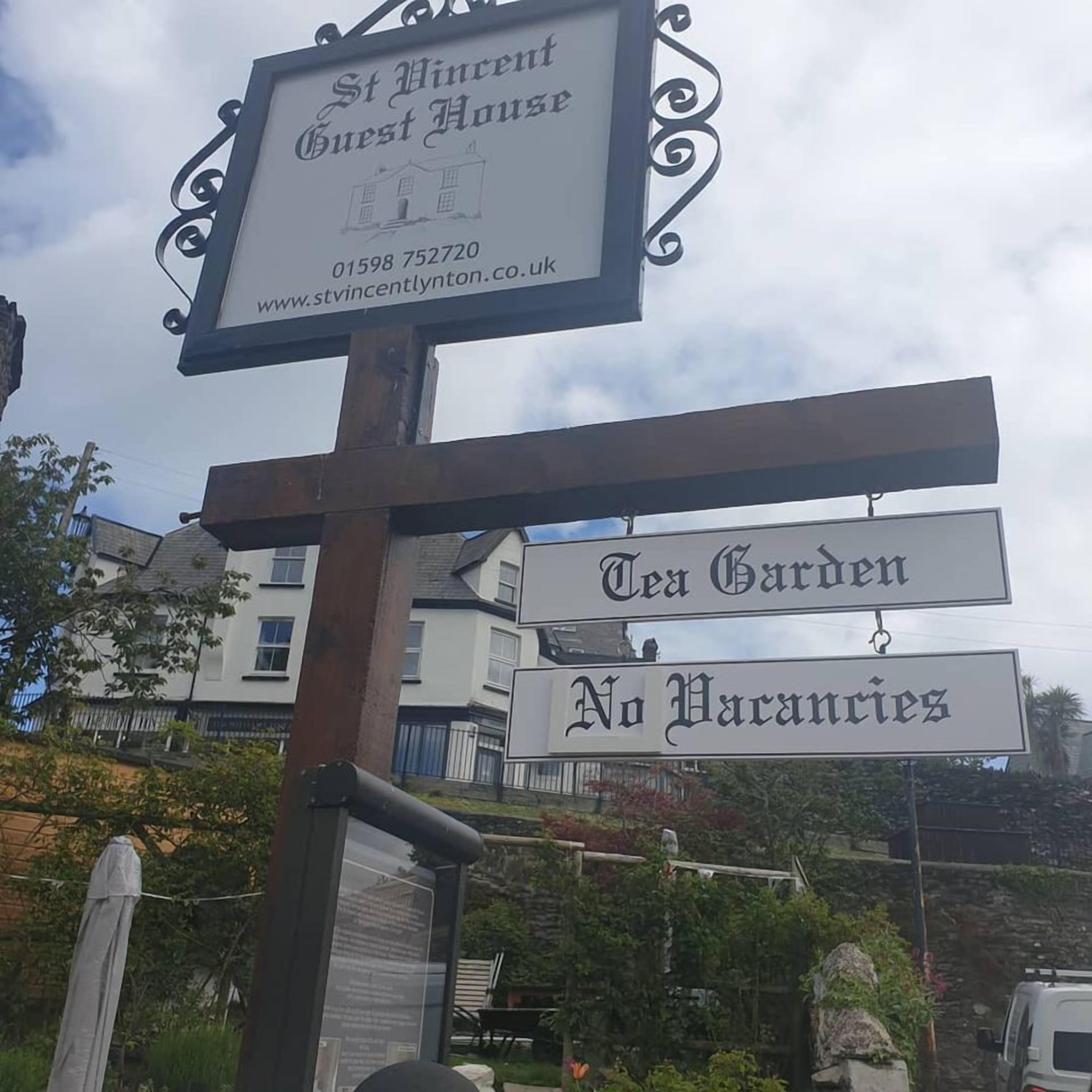Un panneau indicateur portant les inscriptions « St Vincent Guest House » et « Tea Garden », ainsi qu’un panneau indiquant « Complet ».